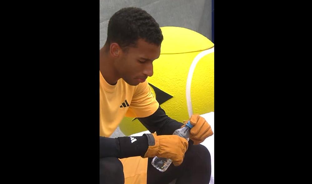 Unreal scene - Auger-Aliassime wearing ski gloves at the changeover in Munich